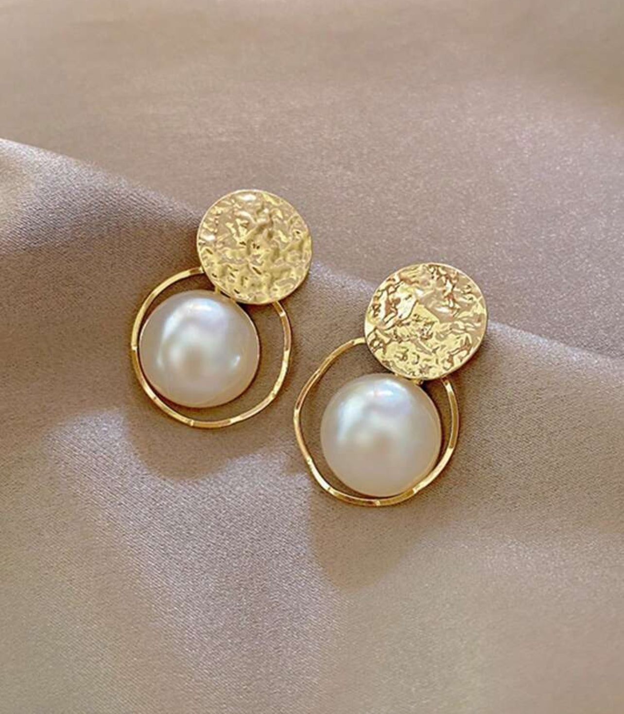 Guldfärgade örhängen med elegant pärla i mitten
